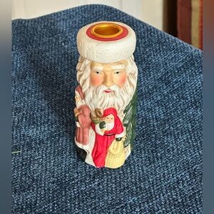 Cute Santa ceramic candleholder. Multiple smaller Santas surrounding the holder.